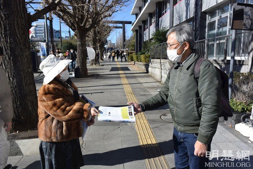 A practitioner offers passersby information about the persecution.