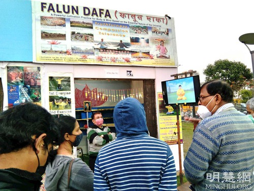 A practitioner (the first right) introduces Falun Dafa to visitors