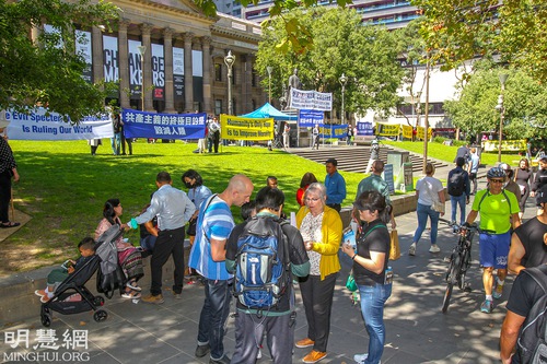 People at the rally sign a petition calling for an end to the CCP’s persecution.