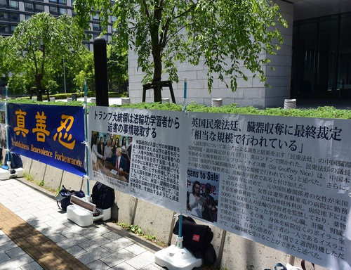 Dafa practitioners set up banners and truth-clarifying panels outside the conference hall of the Quad Summit.