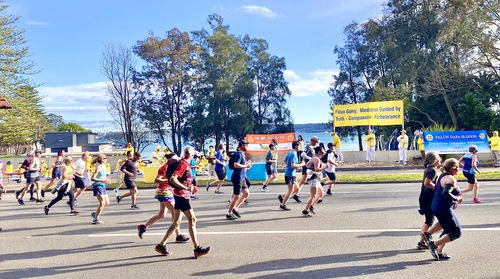 Practitioners demonstrate the exercises while the City2Surf runners pass by.