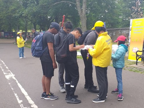 Passersby sign a petition calling for an end to the persecution of Falun Gong.