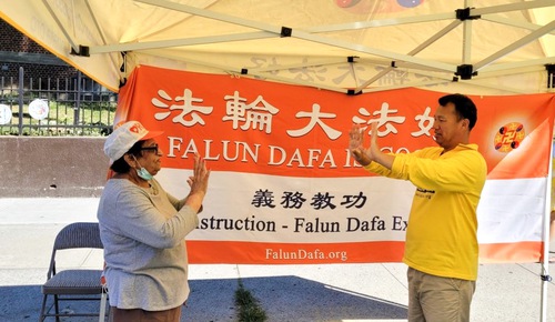 A practitioner teaching Falun Dafa exercises free of charge.