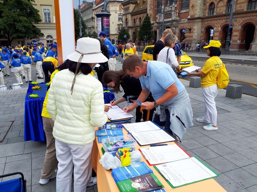 Passersby sign a petition to disintegrate the Chinese Communist Party (CCP).