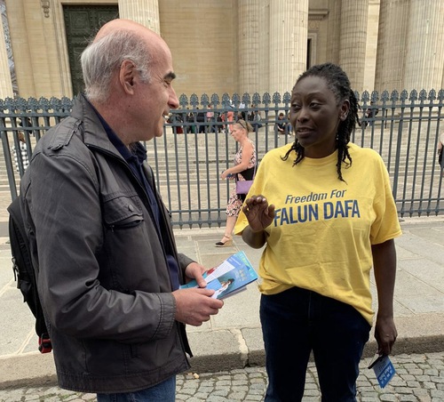 A practitioner tells a passerby about Falun Dafa.
