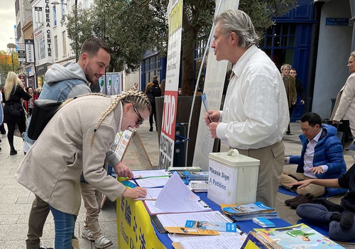 People sign a petition calling for an end to the persecution of Falun Dafa at an event in Dublin on October 22.
