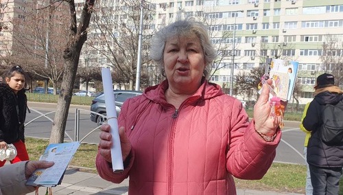 Mrs. Mioara Trifu supports Falun Dafa. She was happy to receive a wall calendar, a pocket calendar, lotus flowers and a leaflet.