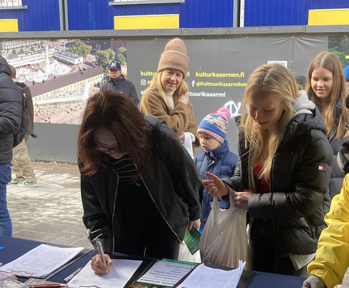Passersby sign the petition to call for an end to the persecution of Falun Gong in China.