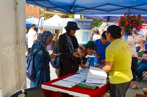 Falun Dafa practitioners talk to passersby about Falun Dafa at the Jubilee Day Street Fair in Mechanicsburg on June 15.
