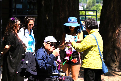A practitioner distributes information about Falun Dafa and lotus flowers.