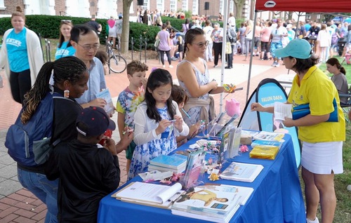 People stopped at the booth to learn about Falun Dafa.