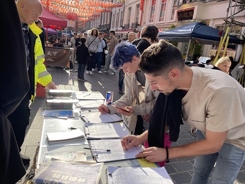 People sign a petition calling for an end to the CCP’s persecution.
