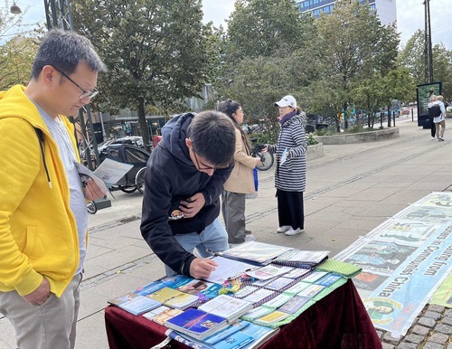People sign the petition in Copenhagen, Denmark to support ending the persecution of Falun Dafa in China.