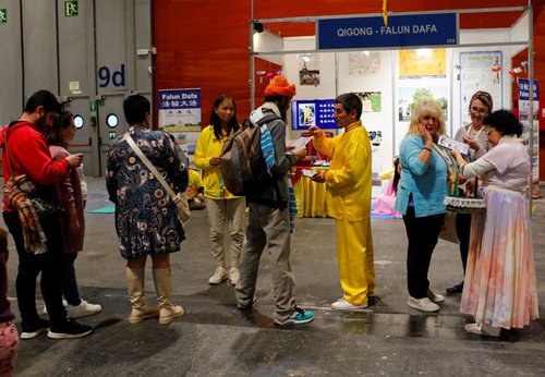 Many people stopped at the Falun Dafa booth and talked with practitioners.