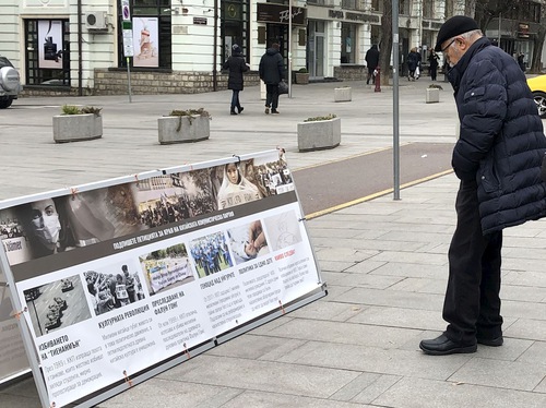 A passerby reads the display boards.