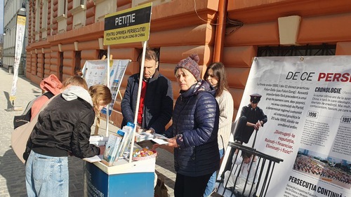 Two young women sign petitions urging to end the persecution of Falun Dafa in China.