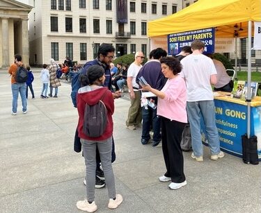 People take flyers and talk with practitioners about Falun Dafa.