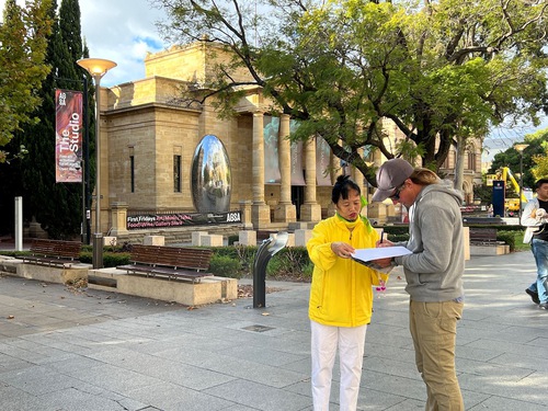 People sign the petition in support of Falun Gong practitioners.