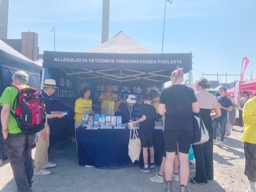 Practitioners introduce Falun Dafa to visitors and tell them about the CCP’s persecution.