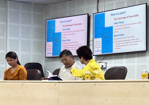 Mr. Rameshdan C. Ghadvi (centre), head registrar at VNSG University, reads Zhuan Falun.