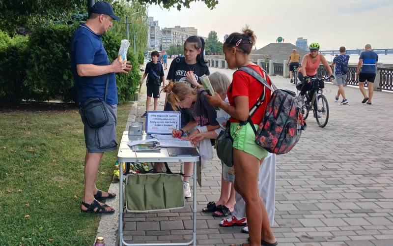 People sign the petition calling to end the CCP during activities in Dnipro.
