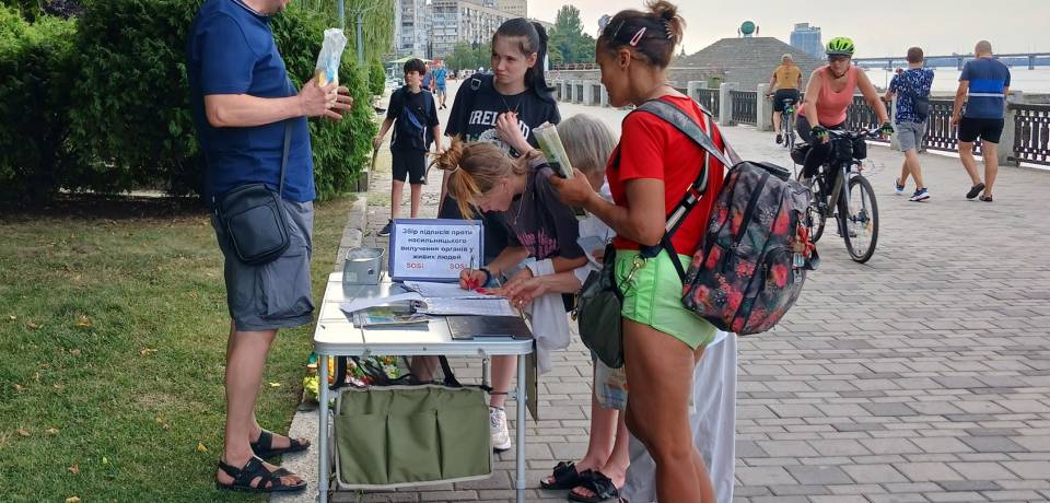 People sign the petition calling to end the CCP during activities in Dnipro.