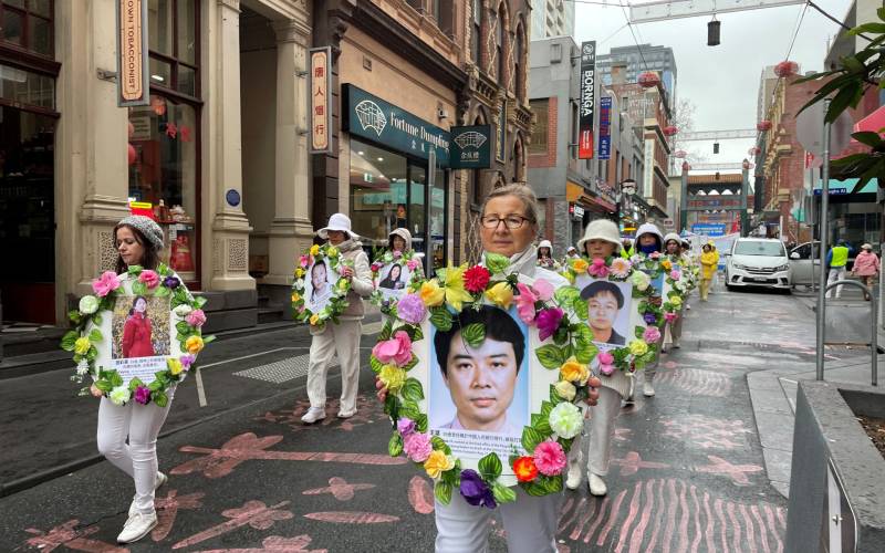 Practitioner Barbara McGuirrin walked in the parade holding a portrait of a practitioner who was murdered during the CCP’s persecution.