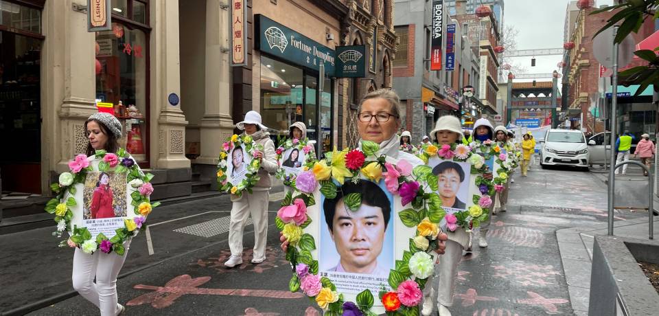 Practitioner Barbara McGuirrin walked in the parade holding a portrait of a practitioner who was murdered during the CCP’s persecution.