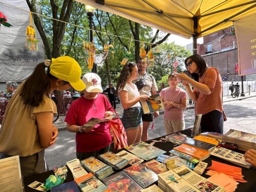 Residents and tourists visited the Falun Dafa booth at the Chinatown Mid-Autumn Festival in Boston’s Chinatown on August 11, 2024.