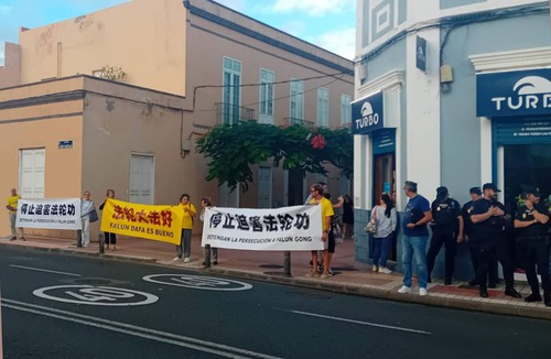 Falun Dafa practitioner held banners in front of Chinese leader Xi Jinping’s hotel in protest, urging him to end the persecution in China.